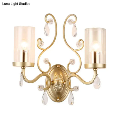 Modern gold crystal wall light featuring clear glass cylinder shade with crystal droplets for bedroom lighting