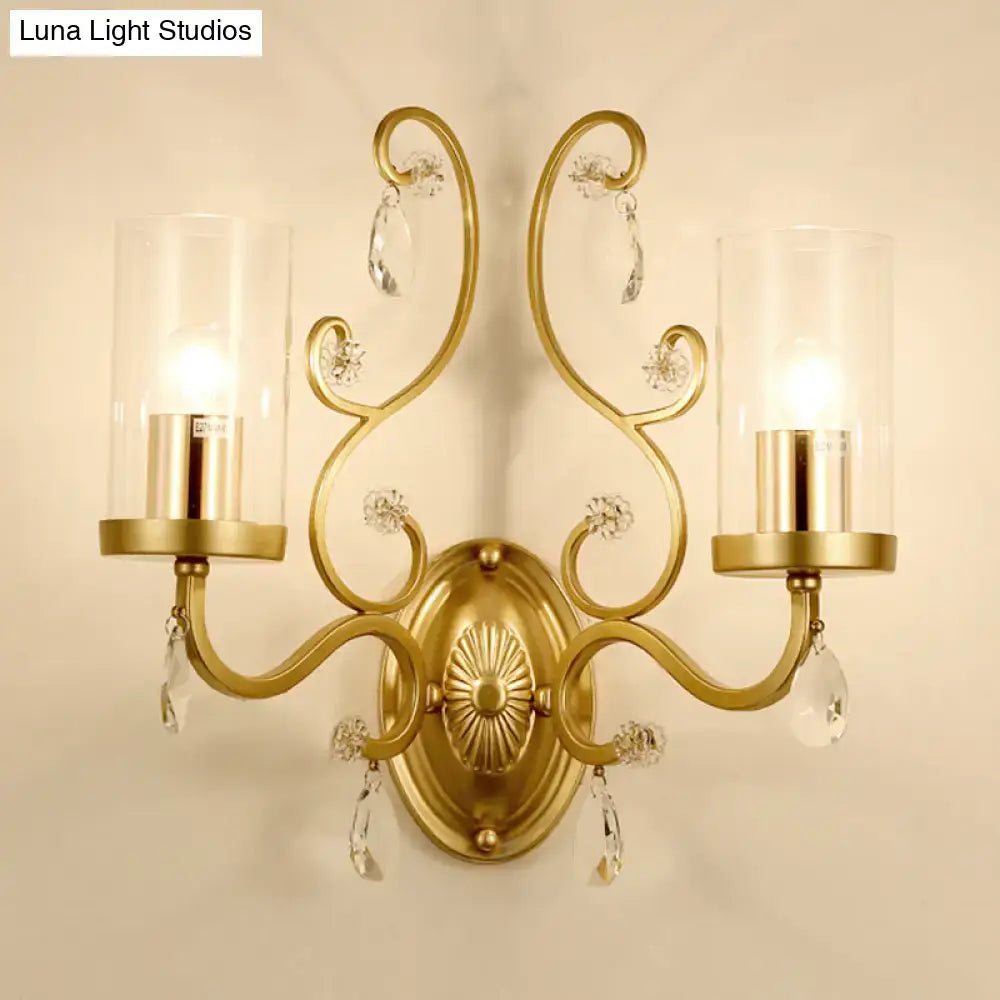 Modern gold crystal wall light featuring a clear glass cylinder shade and ornate gold-toned design with two candle bulbs