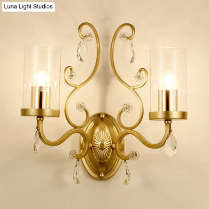 Modern gold crystal wall light featuring a clear glass cylinder shade and ornate gold-toned design with two candle bulbs