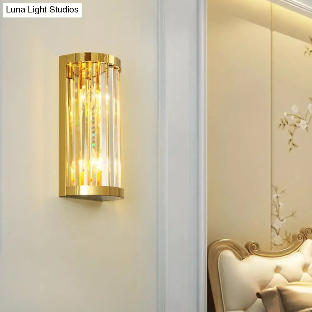 Modern gold crystal wall mount lighting with vertical crystal rods emitting warm glowing light for bedroom use