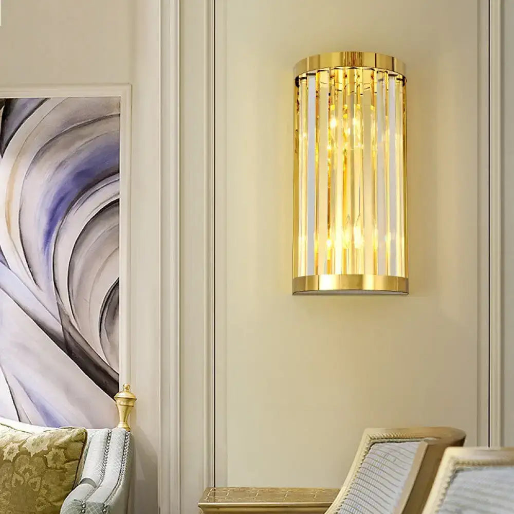 Modern gold crystal wall mount lighting featuring a cylindrical design with vertical crystal rods and polished frame