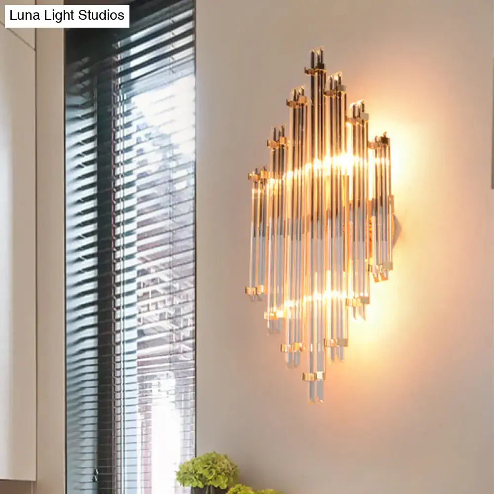 Modern gold crystal wall mounted lamp with clear glass tubes and metallic accents emitting warm glow for living room