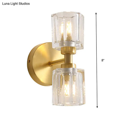 Modern gold crystal wall sconce with two clear faceted glass shades illuminated for living room 12 inch fixture