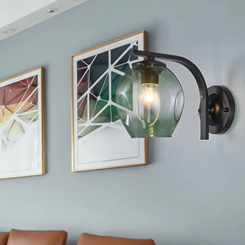 Modern gold curved arm glass wall sconce with blue green translucent globe and exposed filament bulb for bedroom lighting