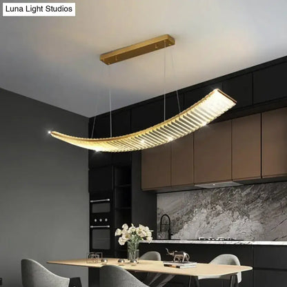 Modern gold curved crystal chandelier with horizontal slats emitting warm light as a suspended crystal chandelier