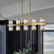 Modern gold cylinder island light fixture with clear glass candle-style shades for dining room chandelier use