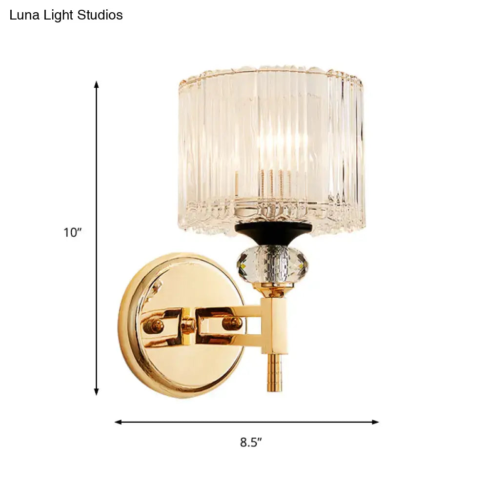 Modern gold cylinder sconce wall lamp with cylindrical crystal glass shade and faceted crystal accent bead for bedroom