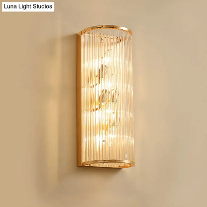 Modern gold cylinder wall mount lamp featuring vertical crystal rods and a warm glowing light for hallway use