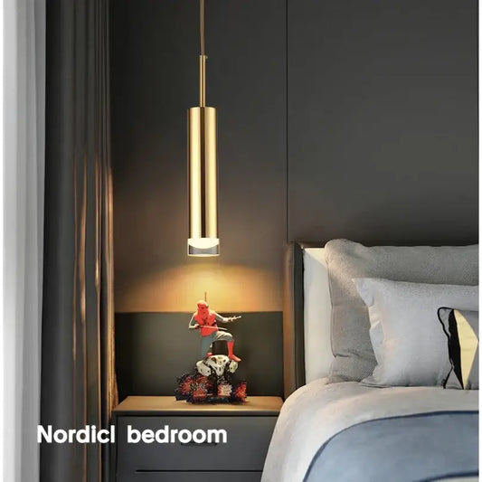 Modern gold cylindrical led pendant light with sleek design hanging above bedside table for decorbites gold modern decor
