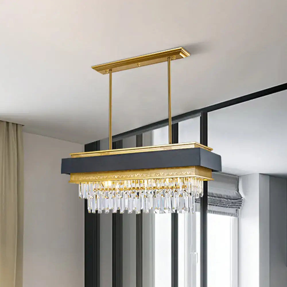 Gold-framed rectangular hanging light with dark gray panel and clear crystal prisms for modern island lighting