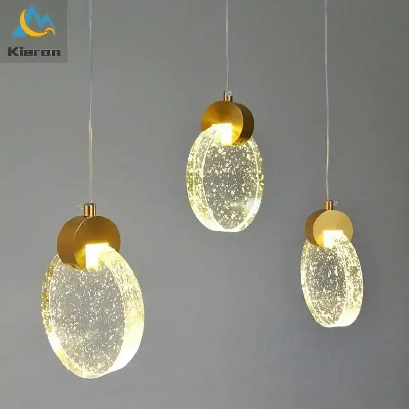 Three modern gold decorbites crystal led bedroom pendant lights with translucent bubble-filled glass shades emitting warm glow