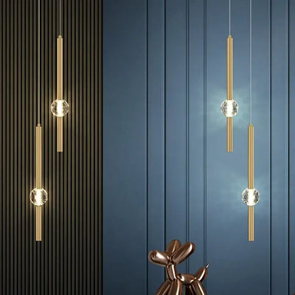 Modern gold decorbites crystal led pendant light featuring gold-toned cylinders and clear crystal spheres suspended by cords