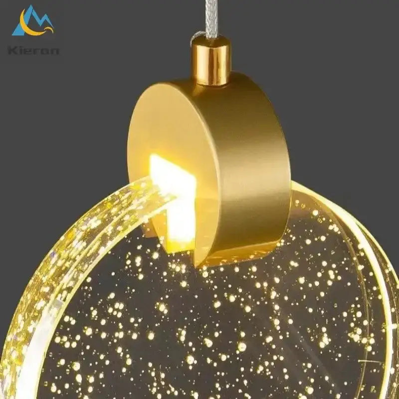 Modern gold decorbites crystal led pendant light with circular glass globe filled with sparkling golden lights