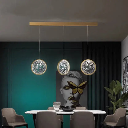 Three modern decorbites crystal pendant lights with gold-toned frames and intricate glass patterns for dining room lighting