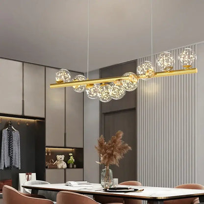 Modern gold decorbites glass ball g9 led chandelier with clear glass globe bulbs on a sleek horizontal bar for dining room light
