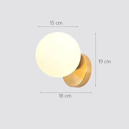 Modern brass-finished wall lamp with frosted glass ball diffuser decorbites glass ball wall sconce for bedroom use