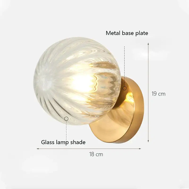 Modern gold decorbites glass ball wall lamp with textured spherical glass shade and polished brass base plate for bedroom sconce