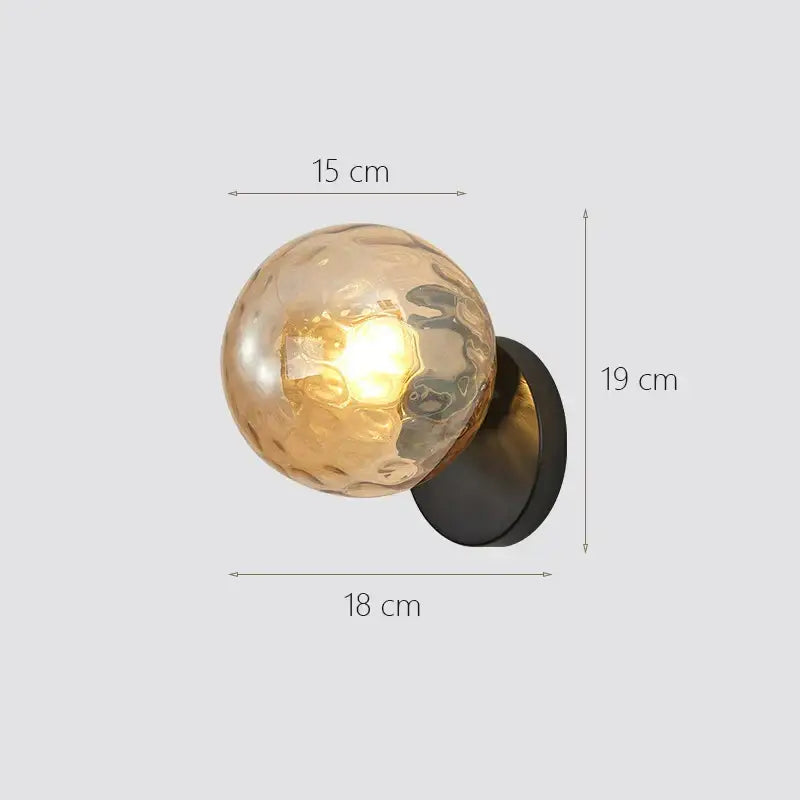 A warm-toned textured glass ball wall sconce with a matte black base modern gold decorbites glass ball wall lamp