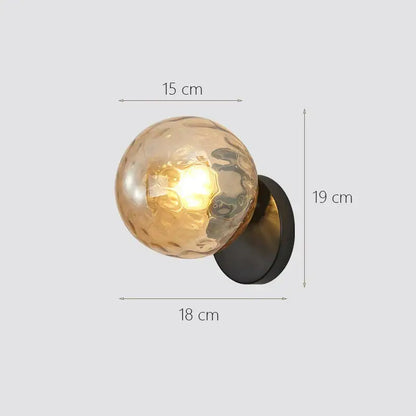 A warm-toned textured glass ball wall sconce with a matte black base modern gold decorbites glass ball wall lamp