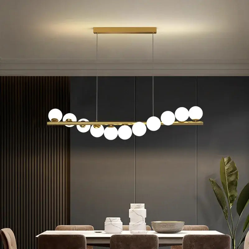 Modern gold decorbites glass balls chandelier with sleek horizontal bar and white spherical glass bulbs for dining room