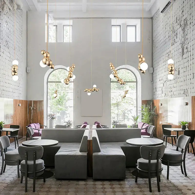 Modern gold designer molecule chandelier features gold-toned spherical pendant lights for stylish café decorbites designer lighting