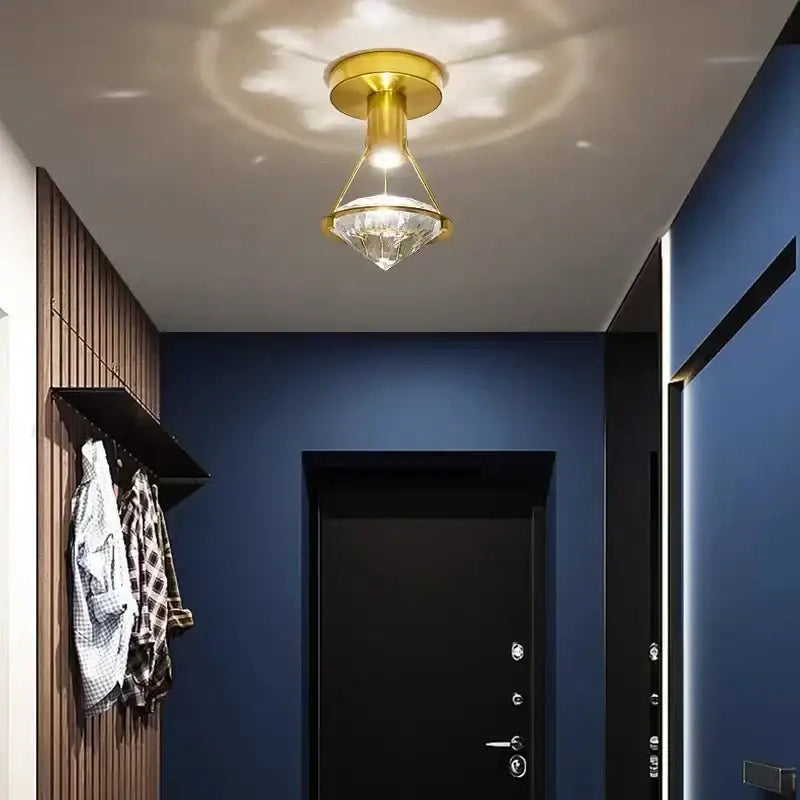 Modern gold diamond crystal wall lamp featuring a faceted crystal pendant for elegant bedroom lighting