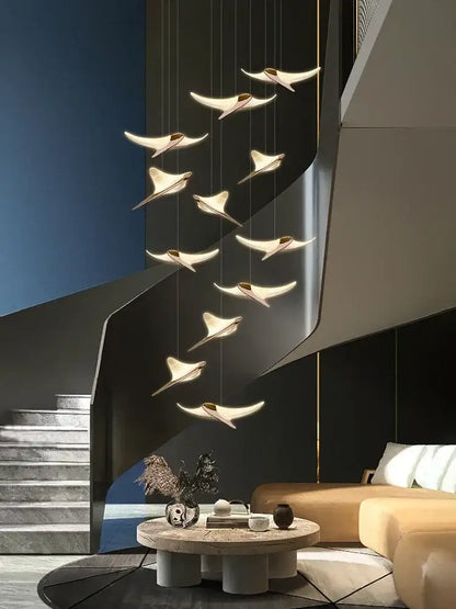 Modern gold dolphin pendant chandelier with sleek wing-shaped light fixtures in warm glow for hotel lobby decorbites dolphin pendant