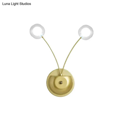 Modern gold double arm wall lamp with clear glass globe bulbs in a gold-toned inch fixture for bedroom use
