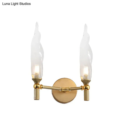 Modern gold double arm wall sconce with flame-shaped glass shades ideal for living room lighting