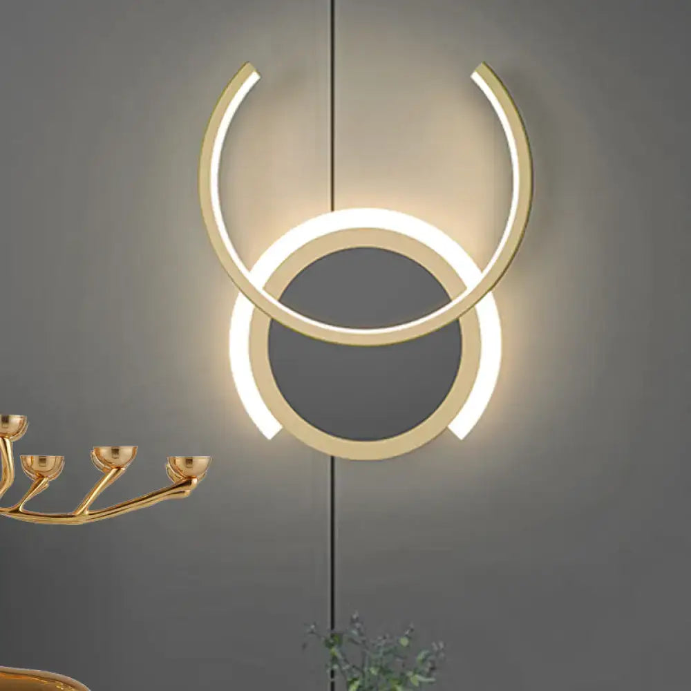 Modern gold dual ring led wall sconce with two concentric circular rings glowing warmly for bedroom lighting
