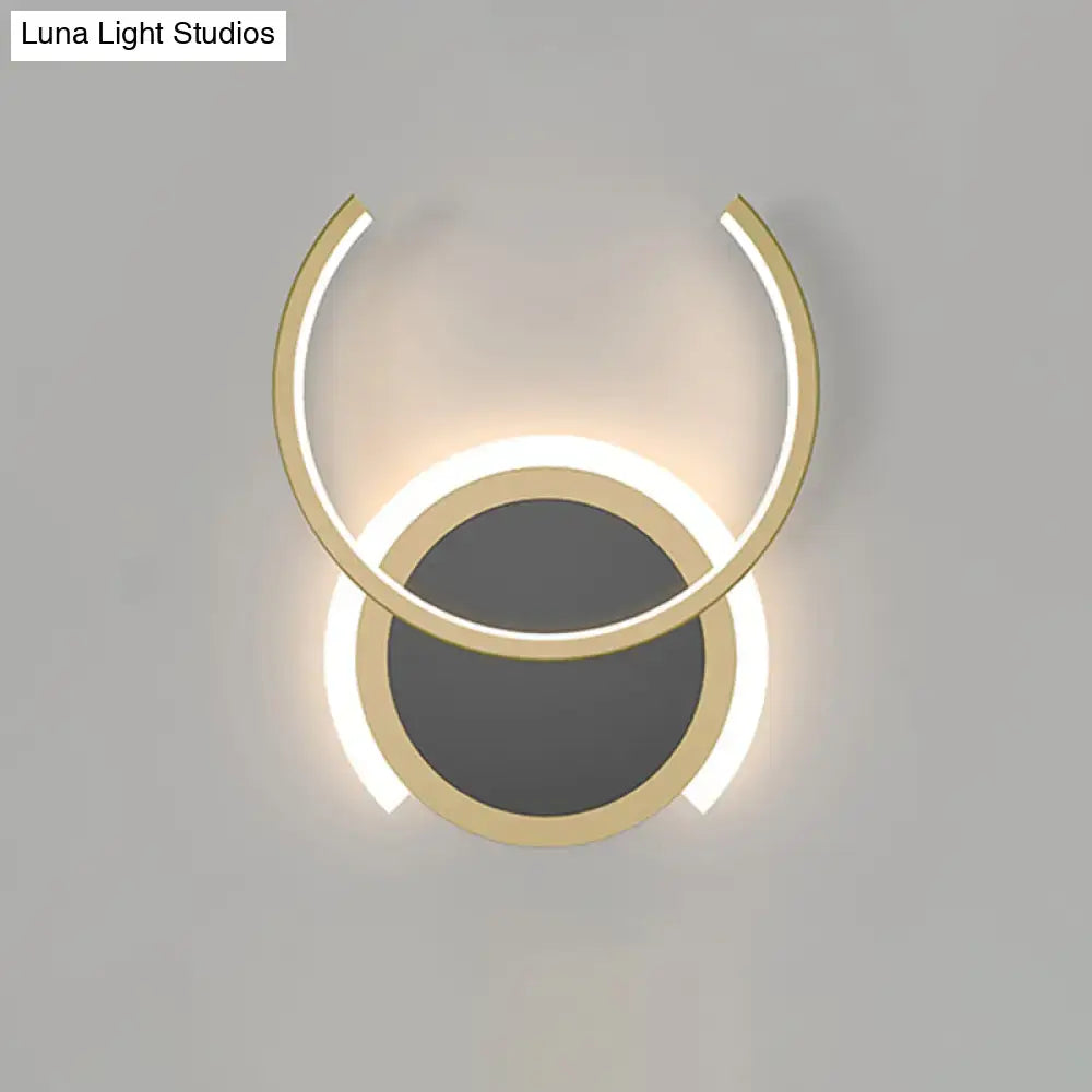 Modern gold dual ring led wall sconce with two concentric circular rings emitting a warm glow for bedroom lighting