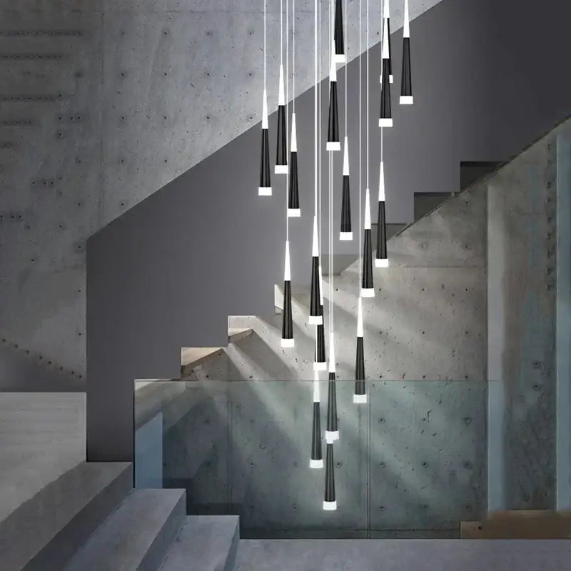 Modern black and white conical pendant lights hang in a cascading arrangement above the staircase with decorbites elegant led features