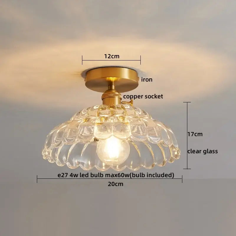 A clear glass led ceiling lamp with brass iron base and copper socket featuring an elegant scalloped design
