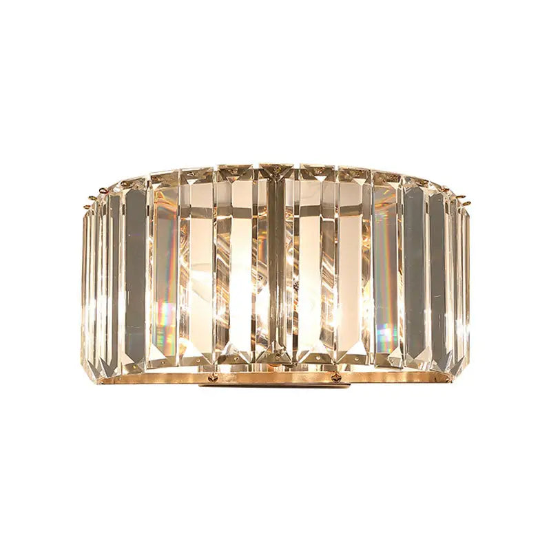 Modern wall sconce with vertical faceted crystal panels in a gold finish metal frame for bedroom lighting