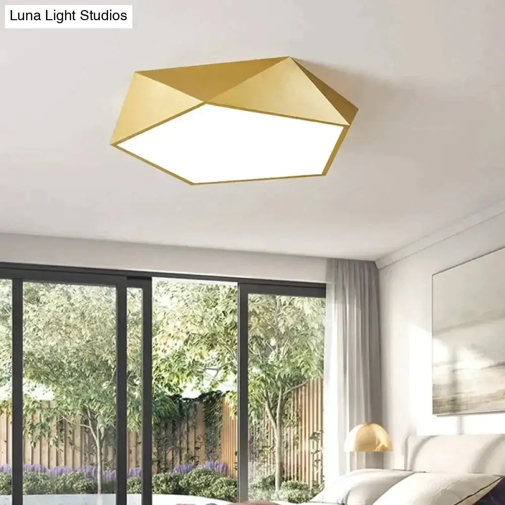 Gold geometric ceiling light with a modern faceted design and illuminated white panel for indoor living spaces