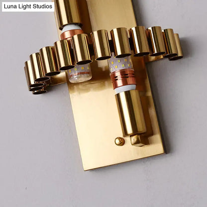 Modern gold finish wall light with clear crystal accents and geometric cylindrical led fixtures for living room use