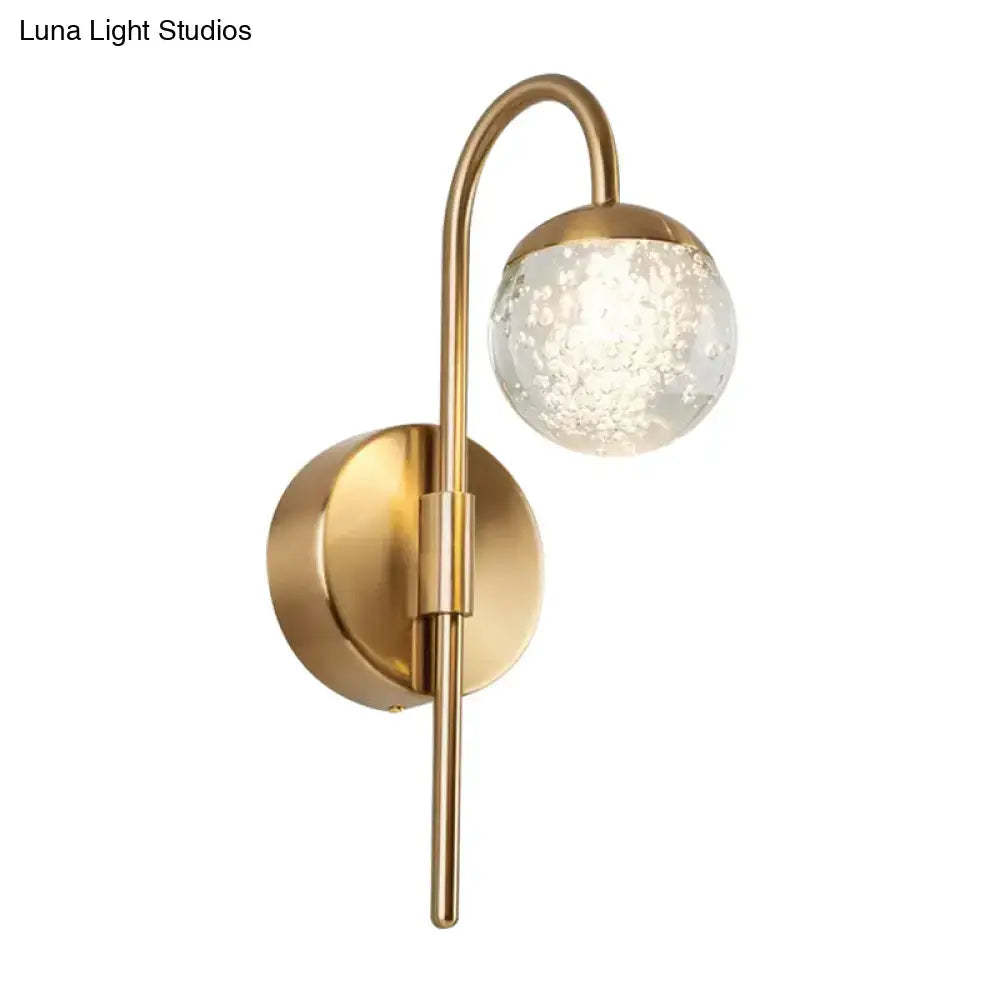 Modern gold finish wall sconce with curved arm and textured bubble glass globe for living room lighting