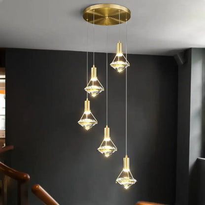 Gold finish pendant light fixture with crystal glass shades hanging from a circular ceiling mount for kitchen island