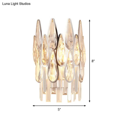 Modern gold finish wall lamp with teardrop crystal glass pieces and sleek chrome frame for bedroom sconce lighting