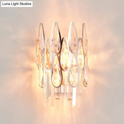 Modern gold finish wall lamp with clear teardrop crystal cluster and sleek chrome base for elegant bedroom sconce