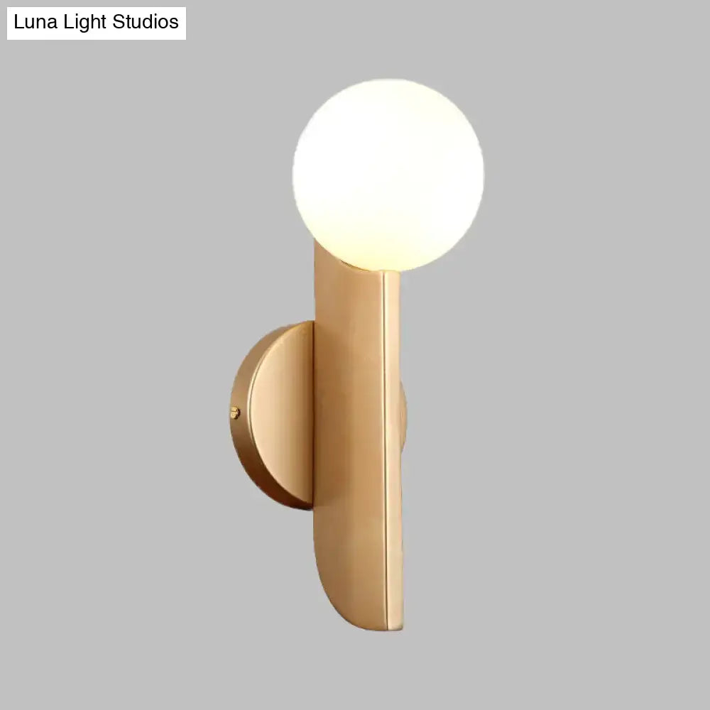 Modern gold finish wall sconce with a milky glass shade and frosted globe for bedroom lighting