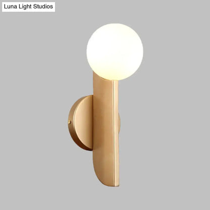 Modern gold finish wall sconce with a milky glass shade and frosted globe for bedroom lighting