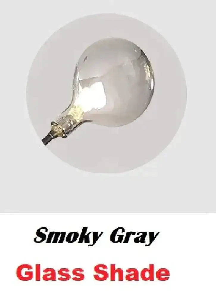 Modern gold firefly tree branch led wall light with a smoky gray glass shade and rounded bulbous metallic base