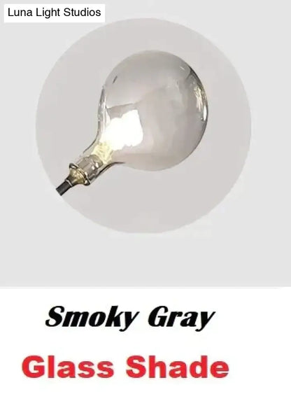 Modern gold firefly tree branch led wall light with smoky gray frosted glass shade and classic bulbous design