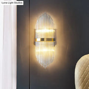 Modern gold flute shaped wall sconce with clear crystal rods and polished metal accents for bedroom lighting