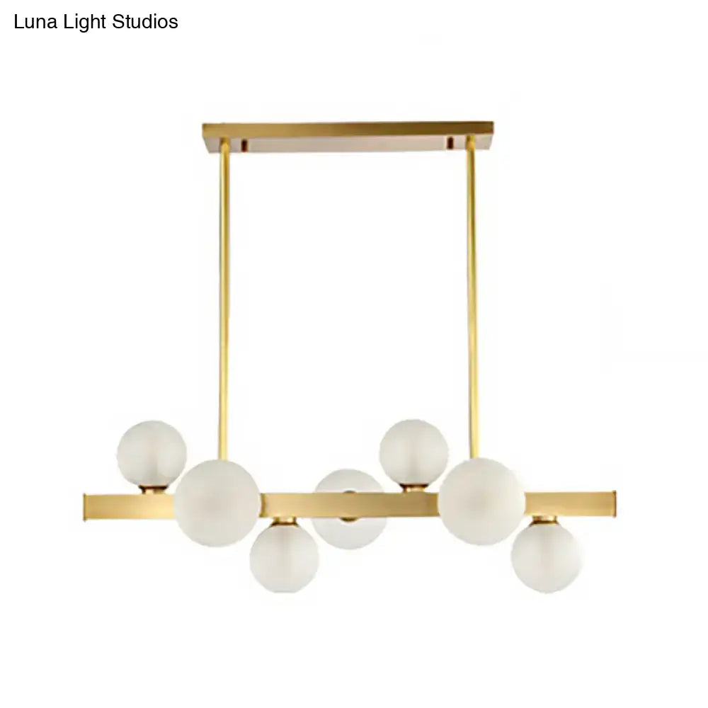 Modern gold pendant light with frosted glass globe bulbs and adjustable chain cord length for dining room island lighting