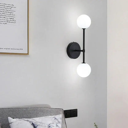 Modern black minimalist led wall sconce with two frosted glass globe shades for bedroom lighting