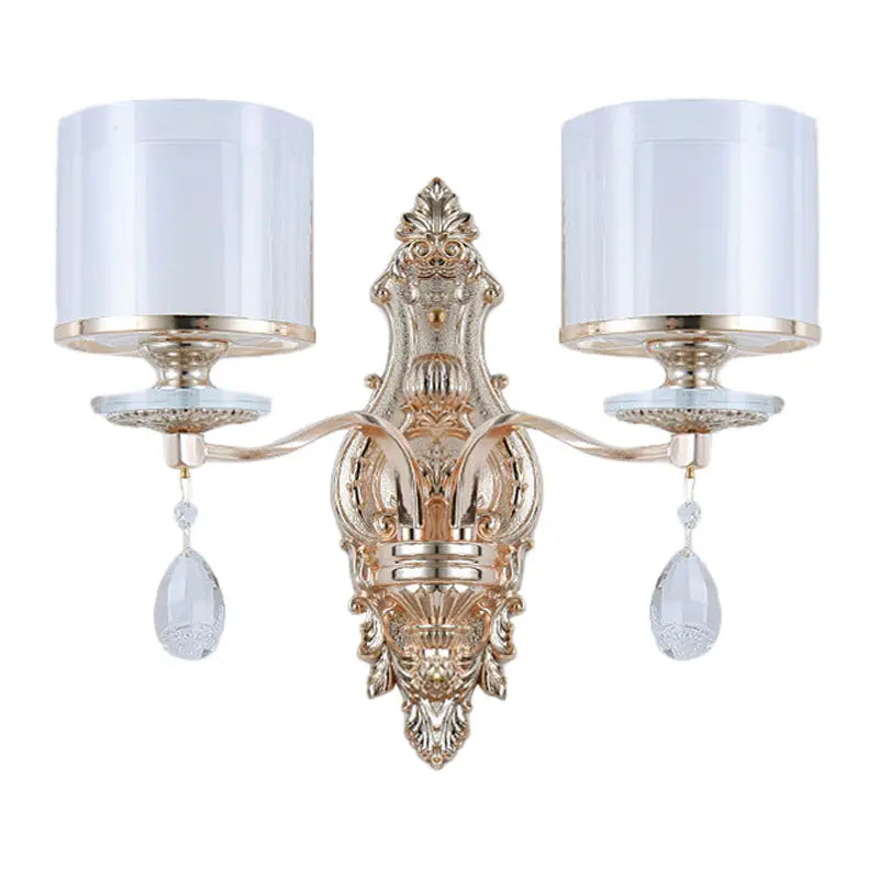 Modern gold wall lamp with frosted glass shades and crystal pendants creating an inviting glow for bedrooms