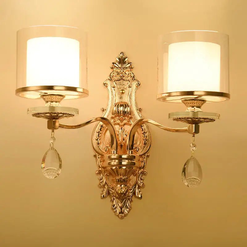 Modern gold wall lamp with frosted glass shades and crystal pendants creating an inviting glow for bedrooms