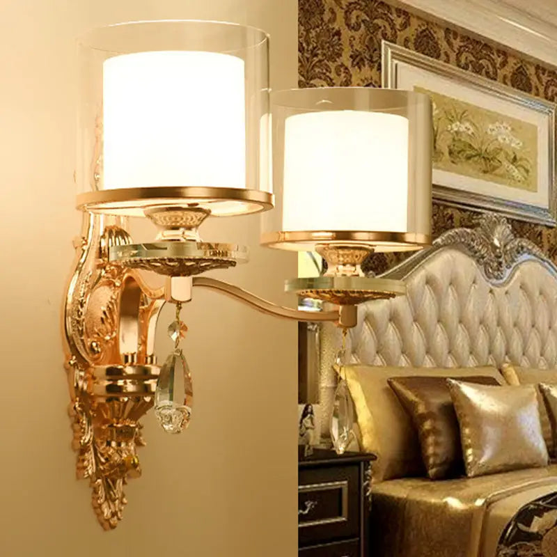 Modern gold ornate wall lamp with frosted glass shades and crystal droplets creating an inviting glow
